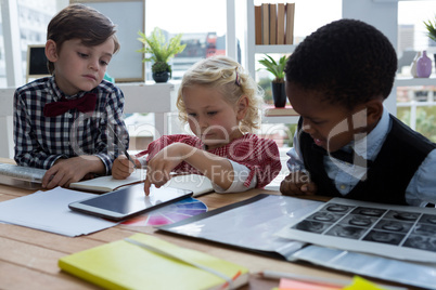 Businesswoman explaining to male colleagues over tablet in office