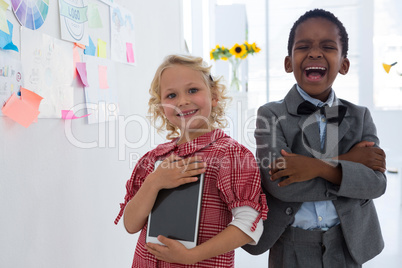 Portrait of cheerful business people standing by whiteboard in office