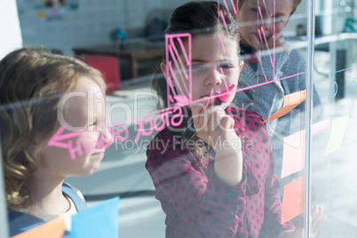 Businesswoman explaining graph to colleagues seen through glass