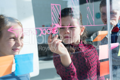 Businesswoman explaining graph to coworkers seen through glass