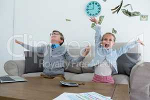 Colleagues throwing currency while sitting on sofa
