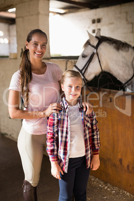 Portrait of sisters standing by horse