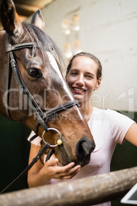 Portrait of female jockey by horse
