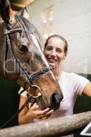 Portrait of female jockey by horse