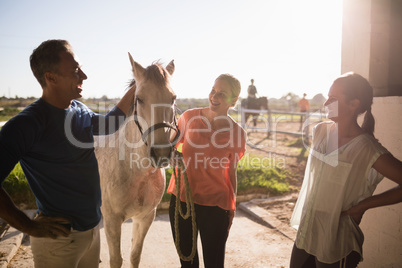 Trainer talking to women while standing by horse
