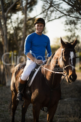 Portrait of male jockey riding horse