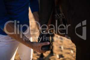 Midsection of male trainer adjusting woman leg on stirrup