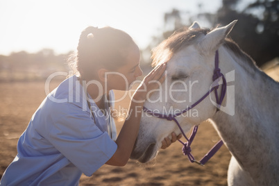 side view of female vet stroking horse