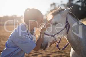 side view of female vet stroking horse