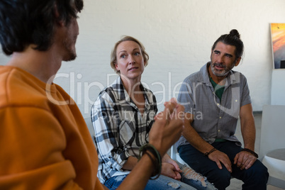 Friends discussing while sitting on chair