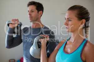 Confident athletes exercising with kettlebells