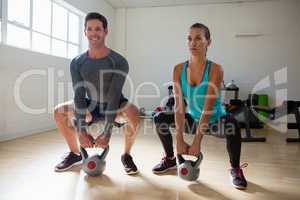 Athletes lifting kettlebells in health club