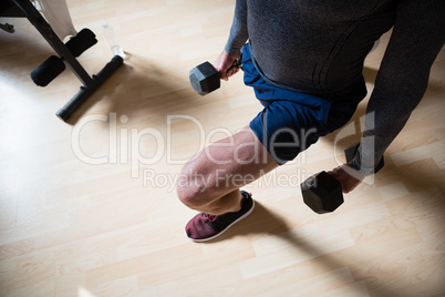 Low section of male athlete exercising lunges in fitness club