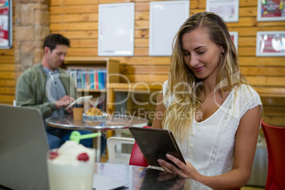 Young woman using tablet in cafe