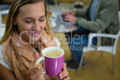 Close up of young woman holding coffee cup in gym