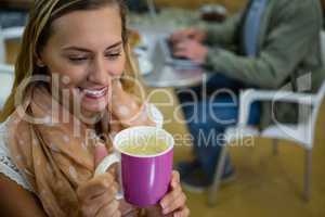 Close up of young woman holding coffee cup in gym