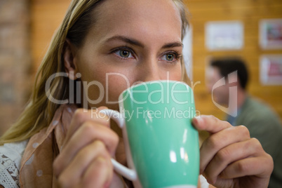 Close of thoughtful woman having coffee in cafe