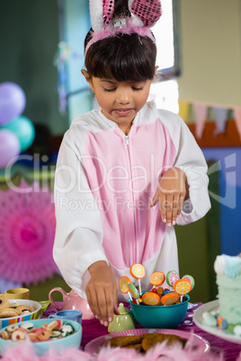 Girl having cookies during birthday party