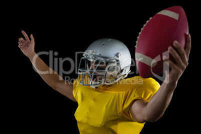American football player cheering with ball in his hand