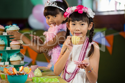 Portrait of cute girls having tea during birthday party