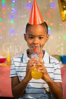 Portrait of happy boy drinking juice during birthday party