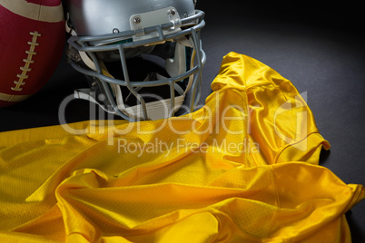 Close-up of American football jersey, head gear and football