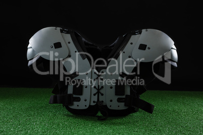 American football shoulder pads over artificial turf