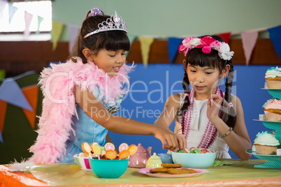 Cute girls having confectionery during birthday party