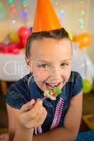 Girl eating cake during birthday party at home