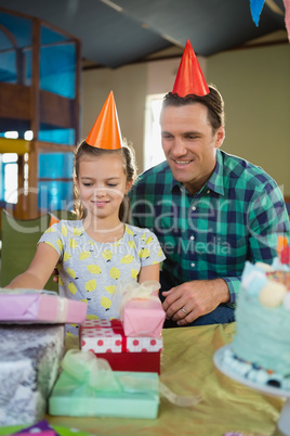 Father and daughter looking at gifts on table