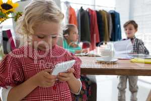 Businesswoman using mobile phone while colleagues working in background