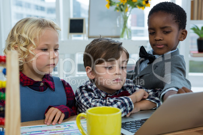 Business people discussing over laptop in office