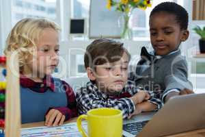 Business people discussing over laptop in office