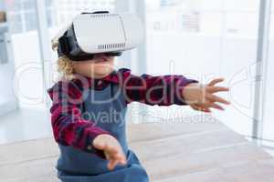Businesswoman looking through virtual reality simulator while sitting on table