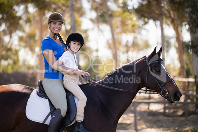 Portrait of Female jockey and girl sitting horseback riding