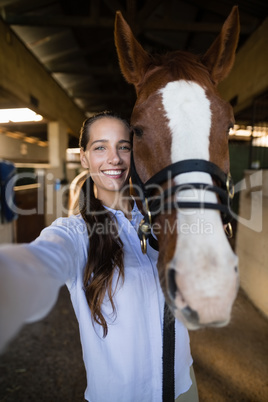 Portrait of female vet standing by horse