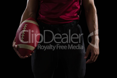 American football player holding a ball in one hand