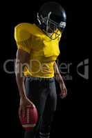 American football player holding a football in his hand