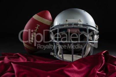 Close-up of American football jersey, head gear and football