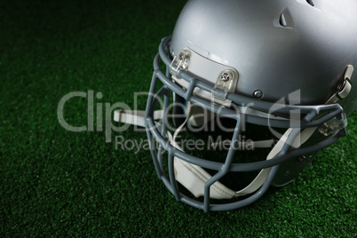 American football head gear over artificial turf