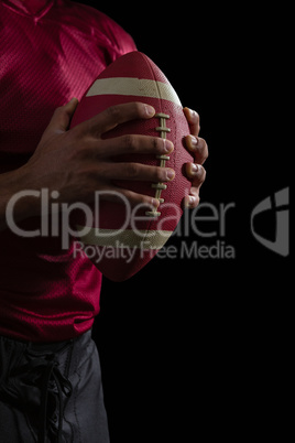 American football player holding a football with both his hands