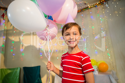 Cute boy holding balloon during birthday party