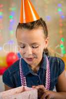 Girl looking at gift bag during birthday party