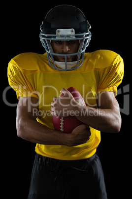 American football player holding a ball in both his arms