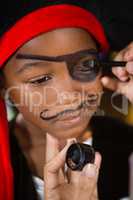 Hand of woman drawing on boy eyes