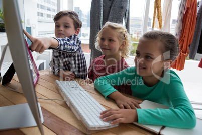 Businessman explaining to female colleagues over computer in office