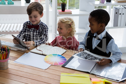 Businessman explaining to colleagues over tablet in office