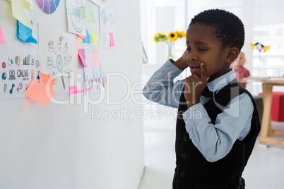 Businessman planning while standing at whiteboard in office