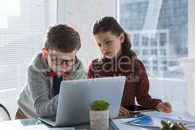 Business people discussing over laptop in office