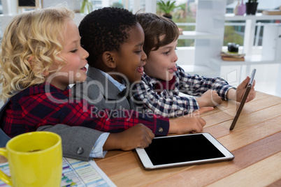 Side view of business people discusisng over tablet in office